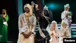 Nigerian Obabiyi Aishah Ajibola is crowned by her predecessor World Muslimah 2012 Nina Septiani of Indonesia (R) after being named World Muslimah 2013 during the third Annual Award of World Muslimah in Jakarta, Sept. 18, 2013. 