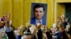 FILE - A supporter holds a portrait of Selahattin Demirtas, detained leader of Turkey's pro-Kurdish opposition Peoples' Democratic Party, at a meeting at the Turkish parliament in Ankara, Nov. 8, 2016.