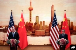 U.S. Secretary of State Mike Pompeo, left, speaks during a joint press conference with Chinese Foreign Minister Wang Yi at the Great Hall of the People in Beijing, June 14, 2018.