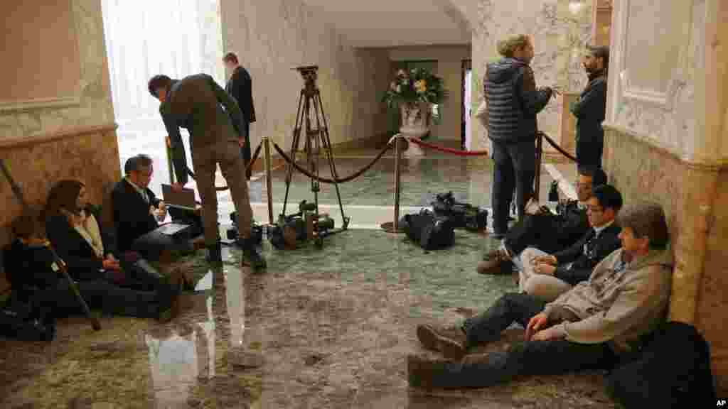 Journalists wait outside the meeting room in Minsk, Belarus, as Ukrainian peace talks dragged on deep into a second day, Feb. 12, 2015. 