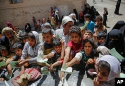 Yemenis present documents in order to receive food rations provided by a local charity, in Sanaa, Yemen, April, 13, 2017.