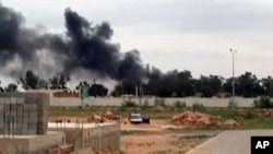 Plumes of smoke rising into the sky at Benina, a civilian and military airport, outside Benghazi in eastern Libya, Mar 17 2011