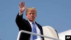 El presidente Donald Trump saluda al abordar el Air Force One para un viaje a West Virginia para una cena de "Saludo al servicio", el 3 de julio de 2018, en la Base Andrews de la Fuerza Aérea, Maryland.