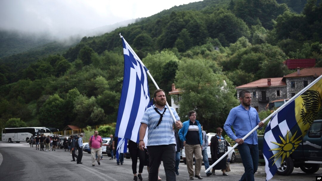 Penentang perjanjian antara Yunani dan Makedonia mengenai perubahan nama Makedonia menjadi Republik Makedonia Utara membawa bendera Yunani ketika protes di desa Pisoderi dekat perbatasan dengan Makedonia di Yunani utara, 17 Juni 2018. 