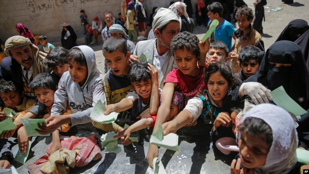 Yemenis present documents in order to receive food rations provided by a local charity, in Sanaa, Yemen, April, 13, 2017. 