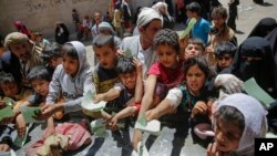 Yemenis present documents in order to receive food rations provided by a local charity, in Sanaa, Yemen, April, 13, 2017. 