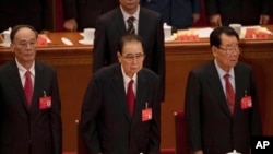 FILE - In this Oct. 24, 2017, photo, former Chinese Premier Li Peng, center, attends the closing session of China's 19th Party Congress at the Great Hall of the People in Beijing, China.