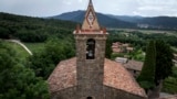 View of the bell tower of the 12th-century Sant Romà church, where students of the Vall d'en Bas School of Bell Ringers perform playing bells, in the small Spanish village of Joanetes, Spain, June 29, 2024. (AP Photo/Emilio Morenatti)