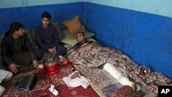Nawid, a 21-year-old student who lost his brother and who was himself wounded in a deadly Taliban suicide attack earlier this month, receives visitors as he lies in bed at home in Kabul, Afghanistan, Jan. 29, 2019.