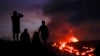 FILE - Orang-orang menyaksikan lava dari gunung berapi Mauna Loa di dekat Hilo, Hawaii, 1 Desember 2022. (Gregory Bull, Arsip/AP)