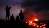 FILE - Orang-orang menyaksikan lava dari gunung berapi Mauna Loa di dekat Hilo, Hawaii, 1 Desember 2022. (Gregory Bull, Arsip/AP)