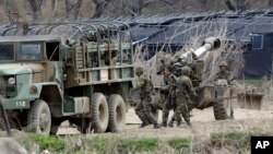 2013年4月18日在韓國首爾北部坡州的兩韓邊境之間﹐韓國士兵在軍事演習期間準備155毫米榴彈砲。