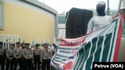 Polisi berjaga di depan Grand City Mall Surabaya, saat anggota FPI menyuarakan larangan pemakaian atribut non muslim bagi karyawan muslim , 18 Desember 2016 (Foto:VOA/Petrus Riski)