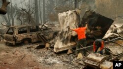 Search and rescue workers search for human remains at a burned out trailer park from the "Camp Fire," Nov. 13, 2018, in Paradise, California.