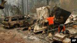 
Petugas SAR mencari sisa-sisa jenazah di taman trailer yang dilalap kebakaran, di Kota Paradise, California, 13 November 2018. 