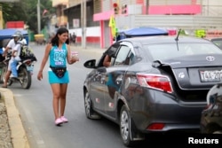 A Venezuelan migrant sells candy on a street in Tumbes, Peru, Aug. 25, 2018.