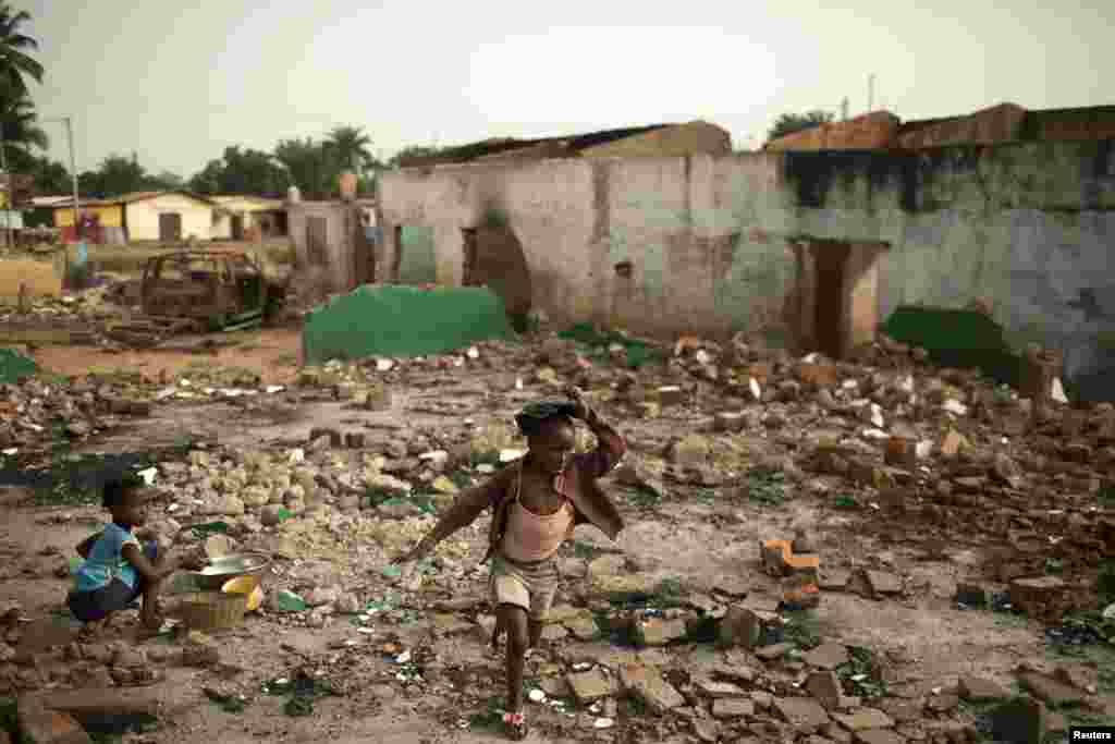 Seorang anak perempuan melintasi puing-puing rumah warga Muslim yang hancur di Miskine, Bangui (5/3).