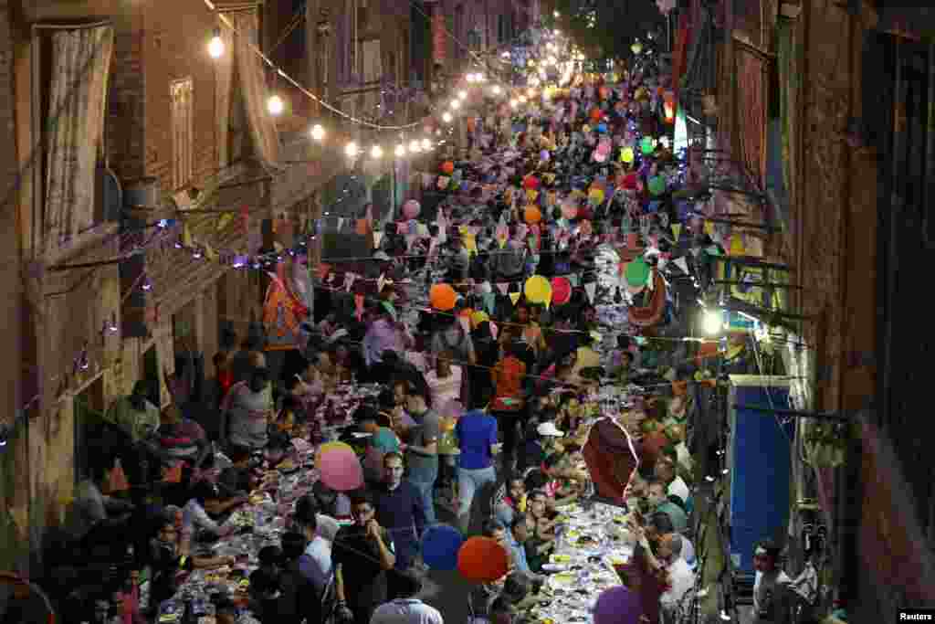 Residents of Ezbet Hamada in Cairo&#39;s Mataria district, Egypt, gather to eat Iftar, the meal to end their fast at sunset, during the holy fasting month of Ramadan, May 20, 2019.