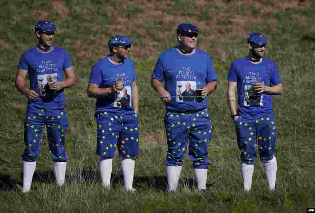 Spectators wearing clothing in the colors of the European Union and images of Europe's Danish captain Thomas Bjorn look on during a practice session ahead of the 42nd Ryder Cup at Le Golf National Course at Saint-Quentin-en-Yvelines, France.