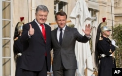 Ukraine's President Petro Poroshenko, left, is welcomed by French President Emmanuel Macron at the Elysee Palace in Paris, France, April 12, 2019.