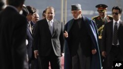 Afghan President Hamid Karzai, center right, talks with Pakistan's Prime Minister Nawaz Sharif while they inspect a guard of honor in Kabul, Afghanistan, in Nov 30, 2013. 