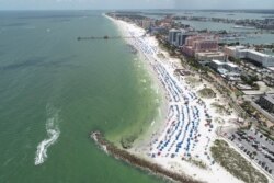 Sun seekers gather at Clearwater Beach, which remains open despite high numbers of coronavirus disease (COVID-19) infections in the state, on Independence Day in Clearwater, Florida, July 4, 2020.