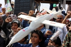 FILE - Houthi rebel supporters carry a mock drone during a rally in Saada, Yemen, Sept. 10, 2019.