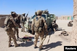 FILE - Afghan Special Forces prepare themselves for battle with the Taliban on the outskirts of Lashkar Gah capital of Helmand, Afghanistan, Oct. 10, 2016.