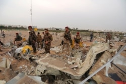 Iraqi army soldiers inspect the destruction at an airport complex under construction in Karbala, Iraq, March 13, 2020. Iraq's military said five security force members and a civilian were killed early Friday in a barrage of U.S. airstrikes.