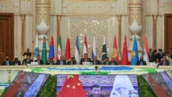 FILE - Participants listen to China's President Xi Jinping, who delivers a speech via a video link during the Shanghai Cooperation Organization summit in Dushanbe, Tajikistan, Sept. 17, 2021.