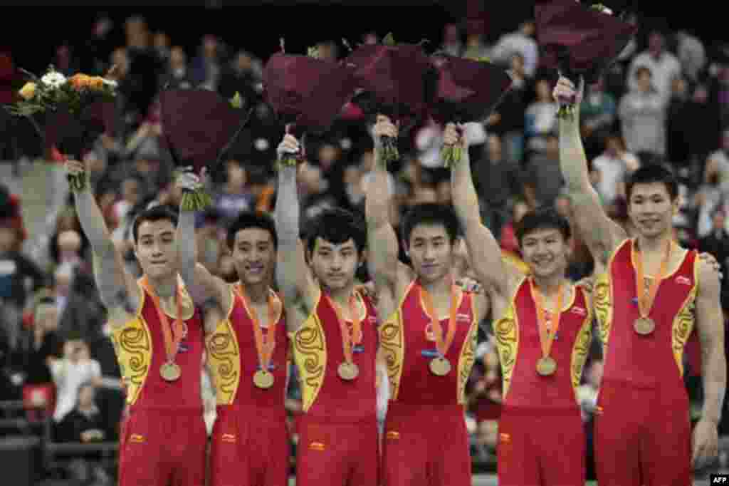 FILE - In this Oct 21, 2010 file photo, gold medallists Zhang Chenglong, Teng Haibin, Feng Zhe, Yan Mingyong, Chen Yibing and Zhang Chenglong of China, left to right, celebrate on the podium after winning the men's team final of the World Championships Gy