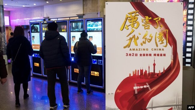 2018年3月9日,上海一家电影院里的《厉害了我的国》影片海报。当局组织中国人去电影院观看这部颂扬共产党和习近平的宣传片 来自公司和政府机构工作人员的大量观看,使票房收入大增,国有媒体称其是该国有史以来收入最高的“纪录片”。