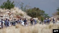 La police fouille des personnes avant qu’elles ne rentrent dans le puit pour négocier avec les mineurs clandestins pour leur retour à la surface à Stilfontein, le 13 novembre 2024.