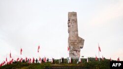 Los exploradores polacos sostienen banderas nacionales de Polonia frente al Monumento a los Defensores de la Costa durante una ceremonia que conmemora el 85º aniversario del inicio de la Segunda Guerra Mundial en la península de Westerplatte en Gdansk el 1 de septiembre de 2024