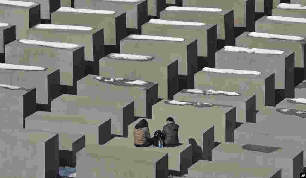 Tourists take a rest at the holocaust memorial in Berlin on a sunny, but cold, Monday.