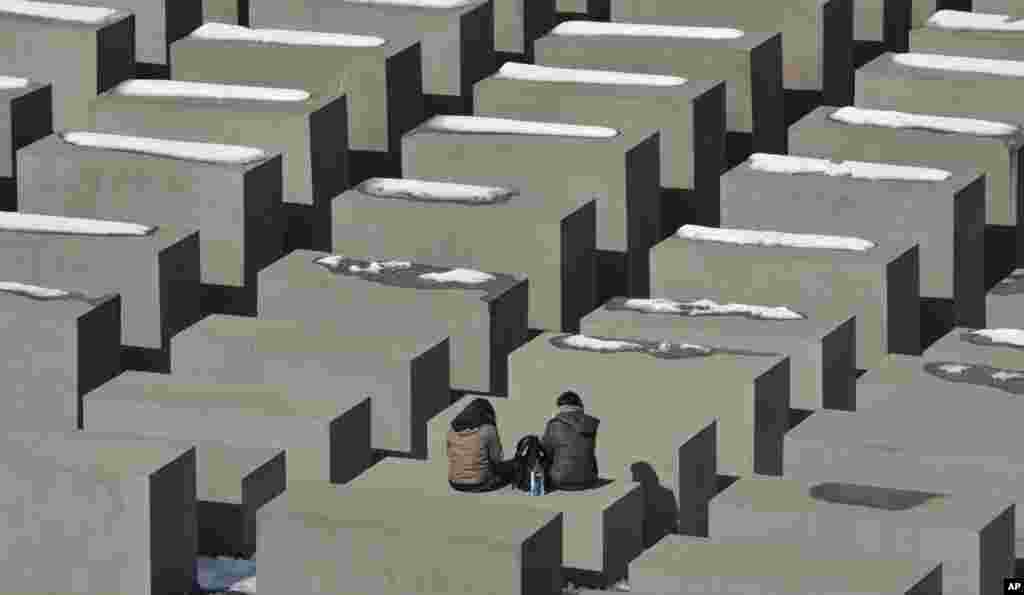 Tourists take a rest at the holocaust memorial in Berlin on a sunny, but cold, Monday. 