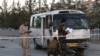 Afghan security personnel investigate a deadly explosion on a mini-bus that was carrying employees of Khorshid TV, in Kabul, Afghanistan, Aug. 4, 2019.