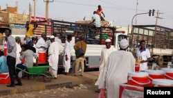 FILE: People gather to ride trucks as they flee during clashes between the paramilitary Rapid Support Forces and the army in Khartoum North. Taken April 26, 2023.