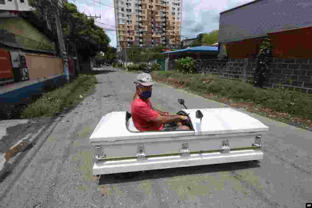 Gabriel Berendo, a businessman and car enthusiast, drives a casket converted into a car in Cebu city, central Philippines, as he goes around streets to remind residents to stay at home as lockdown measures to prevent the spread of the COVIA-19.