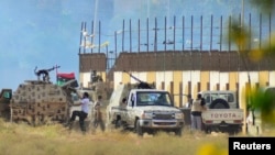 Irregular forces loyal to former army general Khalifa Haftar stand with armed vehicles during clashes with Islamist militants, Benghazi June 2, 2014.