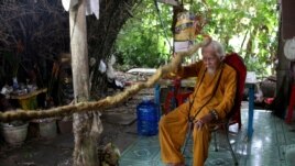 Nguyen Van Chien, 92, sits for a portrait to show his 5-meter long hair which according to him, has not been cut for nearly 80 years, at his home in Tien Giang province, Vietnam, August 21, 2020.