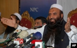FILE - Saifullah Khalid, right, a longtime official of the banned militant Jamaat-ud-Dawa group, and president of the newly-formed Milli Muslim League party, addresses a news conference in Islamabad, Aug. 7, 2017.