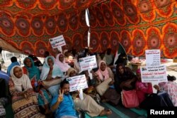 Sudanese protesters gather under a tent to protect themselves from the sun as they sit-in outside the defense ministry compound in Khartoum, Sudan, April 25, 2019.