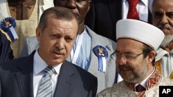 Turkey's Prime Minister Tayyip Erdogan chats with Head of Turkey's Religious Affairs Directorate Mehmet Gormez (R) during the summit of religious leaders from Muslim countries and communities in Africa at the Ottoman-era Dolmabahce Palace in Istanbul, Nov