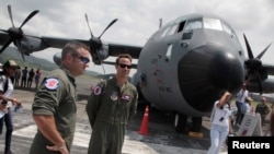 FILE - Members of the flight crew stand in front of the U.S. Air Force Reserve's "Hurricane Hunter" WC-130J aircraft at Panama Pacifico Airport, at an exhibition during its Caribbean Hurricane Awareness Tour, in Panama City, Panama, April 26, 2018. 