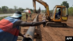 FILE - Workers of Ivory Coast Kuyo pipeline company assemble pipelines in Tiebissou, near Abidjan, the economical capital of Ivory Coast.