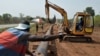 Des ouvriers assemblent un pipeline à Tiebissou, près d'Abidjan, le 24 février 2009 