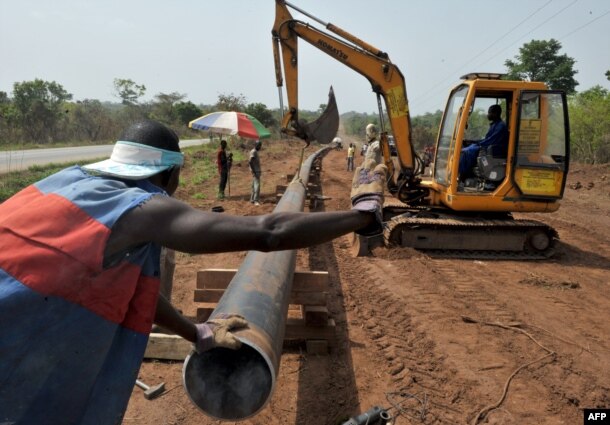 FILE - Workers of Ivory Coast Kuyo pipeline company assemble pipelines in Tiebissou, near Abidjan, the economical capital of Ivory Coast.