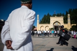 Muslim men arriving at the Id Kah Mosque for morning prayers on Eid al-Fitr in the old town of Kashgar on June 26, 2017.