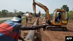 Des ouvriers assemblent un pipeline à Tiebissou, près d'Abidjan, le 24 février 2009 